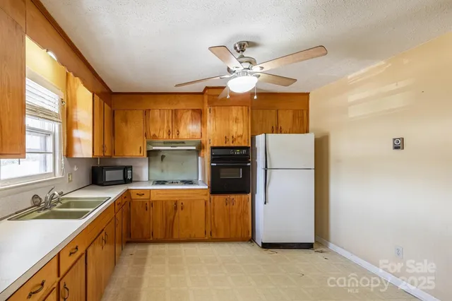a kitchen with kitchen island a large counter top space appliances and a window
