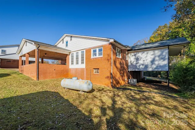 a backyard of a house with wooden fence and large trees