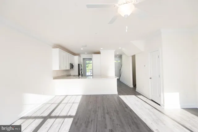 a view of a kitchen with wooden floor and a large window