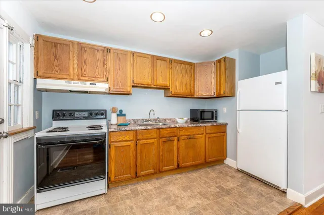 a kitchen with stainless steel appliances granite countertop a refrigerator a stove a sink dishwasher and a refrigerator