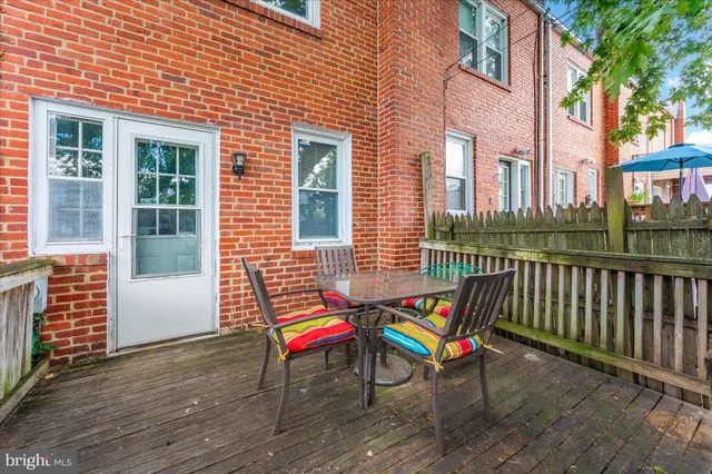 a balcony with wooden floor and outdoor seating