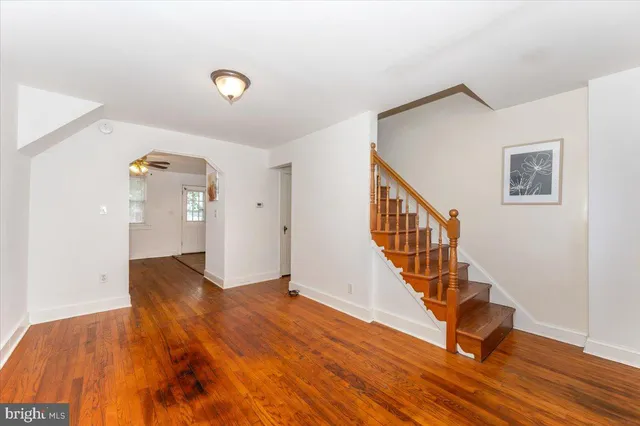 a view of a livingroom with wooden floor and stairs