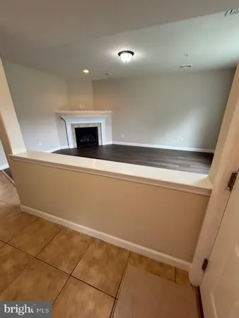 a view of an empty room with a fireplace and a window