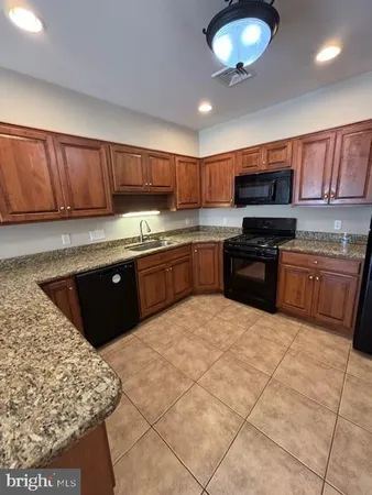 a kitchen with stainless steel appliances granite countertop a stove sink and cabinets