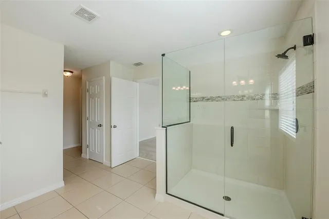 a bathroom with a shower and a glass door