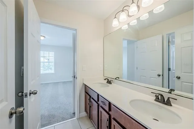 a bathroom with a sink a light fixture and a mirror