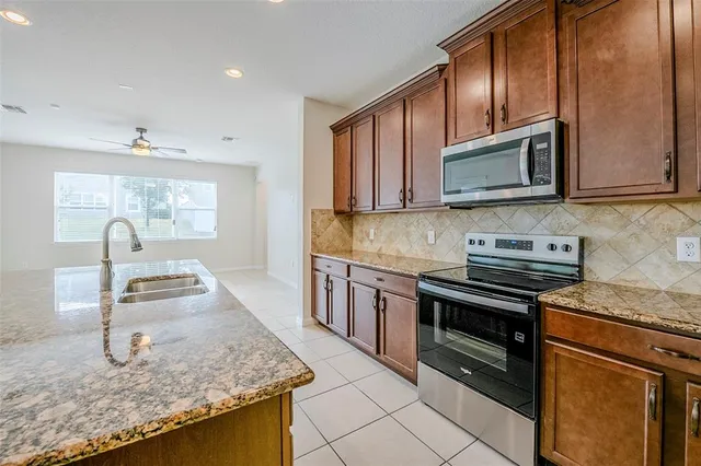 a kitchen with stainless steel appliances granite countertop a sink stove and microwave