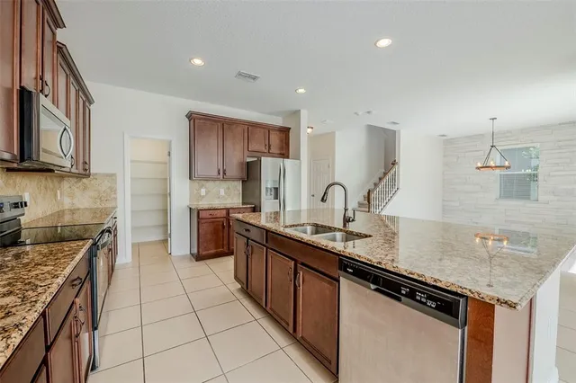 a kitchen with stainless steel appliances granite countertop a sink stove and cabinets