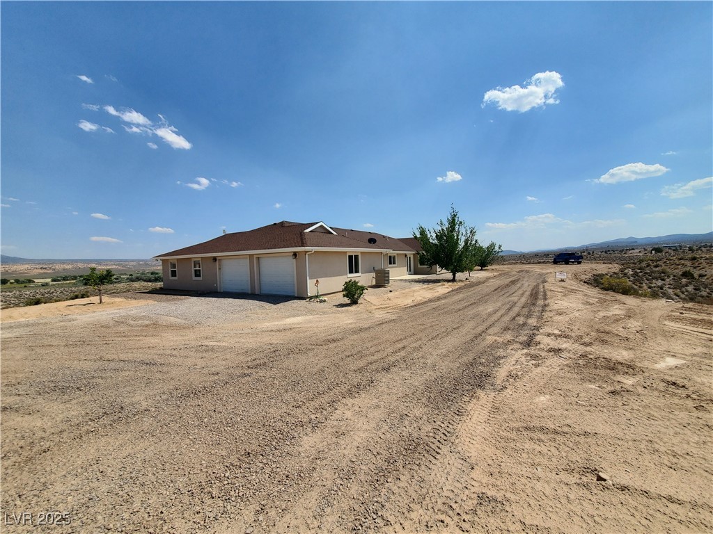 5272 Truman Lane Caliente, NV 89008 - Photo 30 of 39 View of front facade featuring an attached garage, driveway, and stucco siding