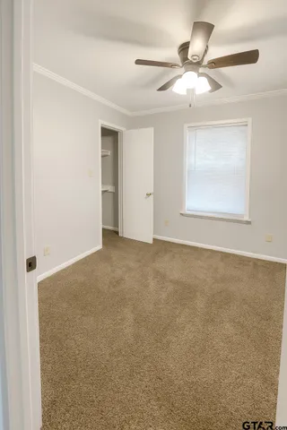 an empty room with a window and a ceiling fan