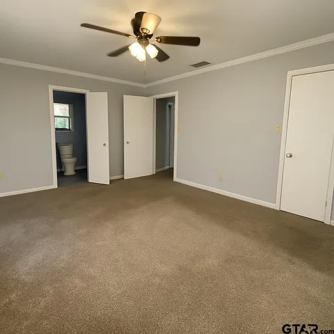 an empty room with a window and a fan