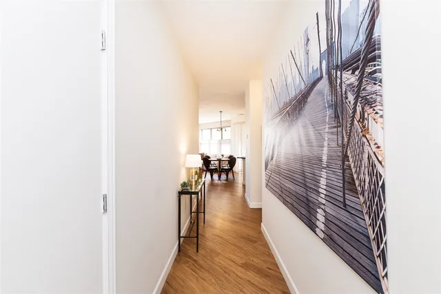 a view of a hallway with wooden floor and a potted plant