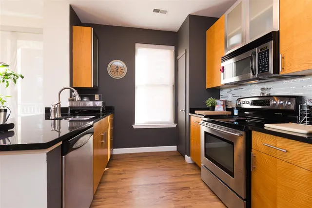 a kitchen with stainless steel appliances granite countertop a sink stove and refrigerator