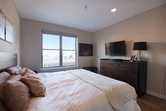 a bedroom with a bed and a flat screen tv