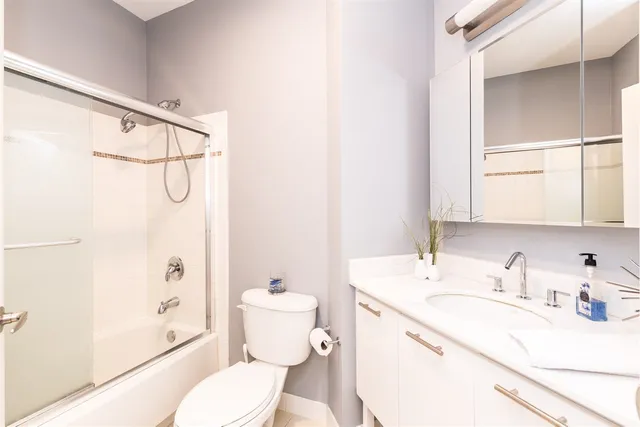 a bathroom with a sink toilet vanity and shower