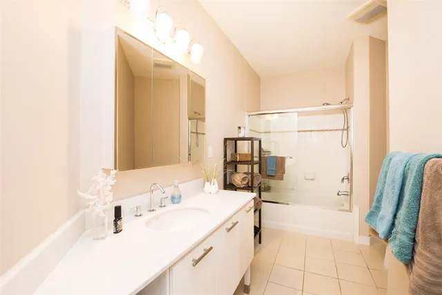 a bathroom with a tub sink and mirror