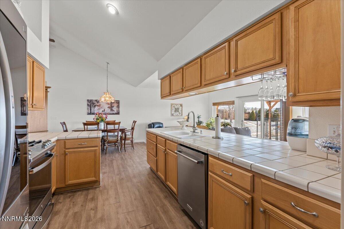 9580 Benedict Drive Sparks, NV 89441 - Photo 13 of 40 a kitchen with stainless steel appliances granite countertop a sink stove and wooden cabinets