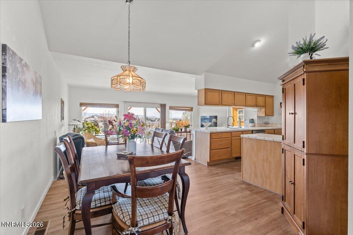 9580 Benedict Drive Sparks, NV 89441 - Photo 9 of 40 a kitchen with refrigerator a dining table and chairs