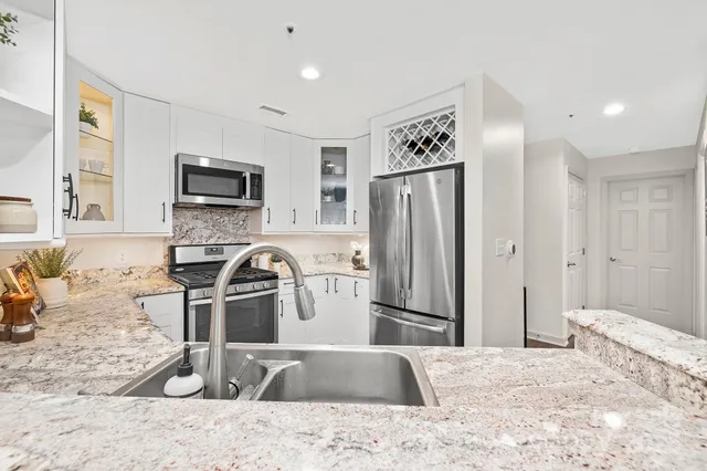 a kitchen with stainless steel appliances granite countertop a refrigerator sink and stove