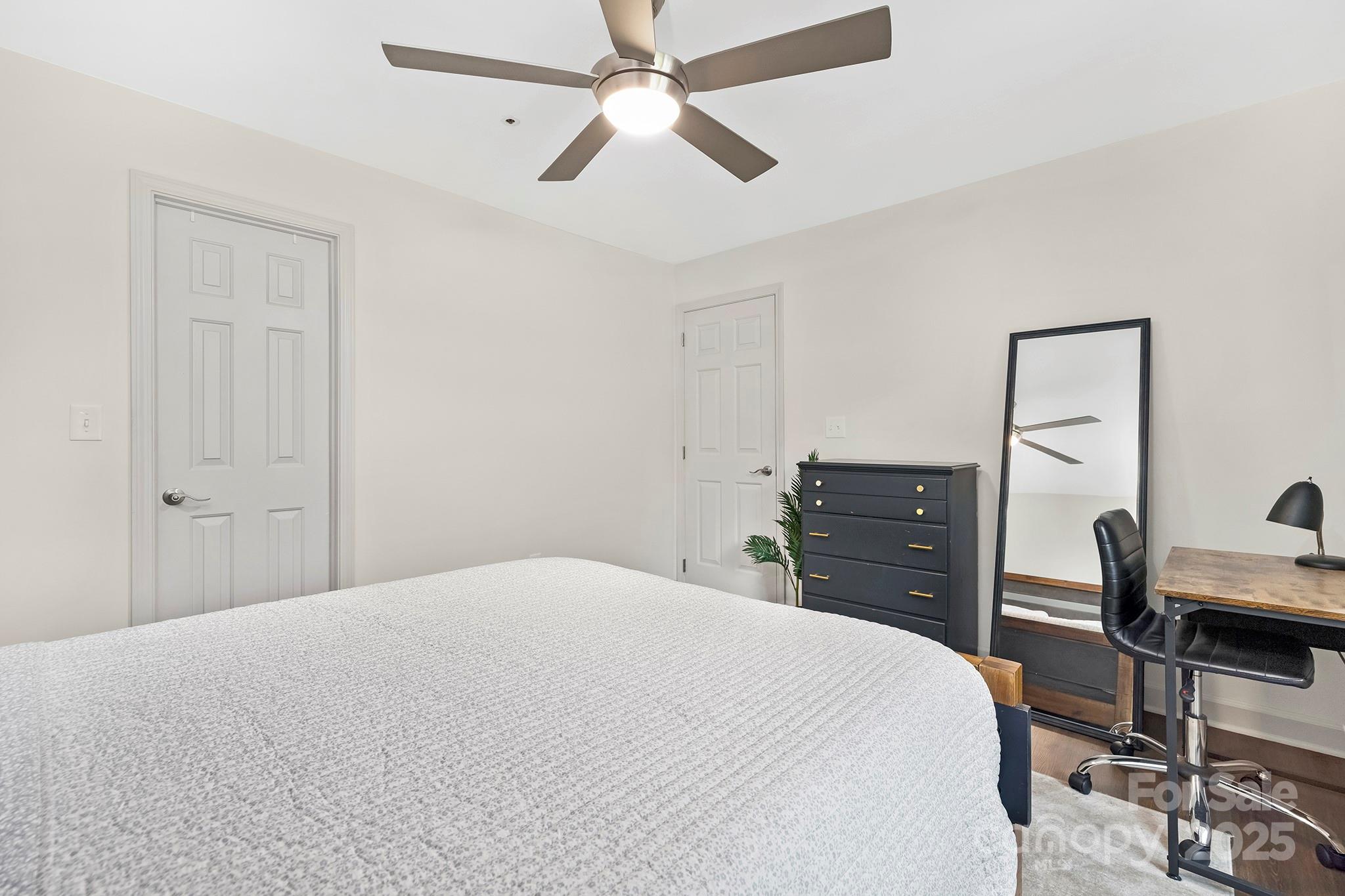 17811 Half Moon Lane, Unit E Cornelius, NC 28031 - Photo 24 of 42 a bedroom with a bed and a chandelier