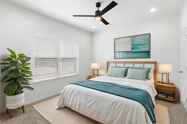 a bedroom with a large bed and a potted plant