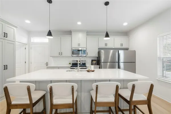 a kitchen with kitchen island granite countertop wooden cabinets and stainless steel appliances