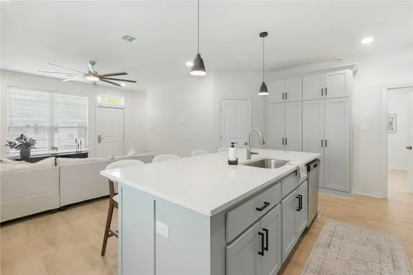 a kitchen with white cabinets sink and stainless steel appliances