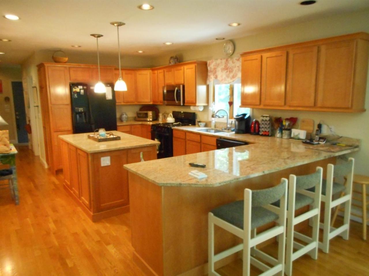 83 Norris Road Sagamore Beach, MA 02562 - Photo 3 of 16 a kitchen with appliances a sink and cabinets