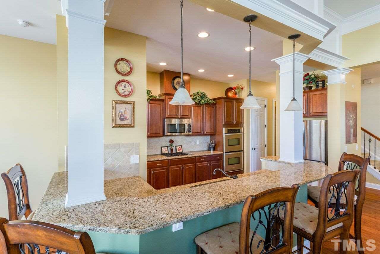1217 Chapanoke Road Raleigh, NC 27603 - Photo 20 of 25 a kitchen with stainless steel appliances granite countertop a stove a sink and a refrigerator