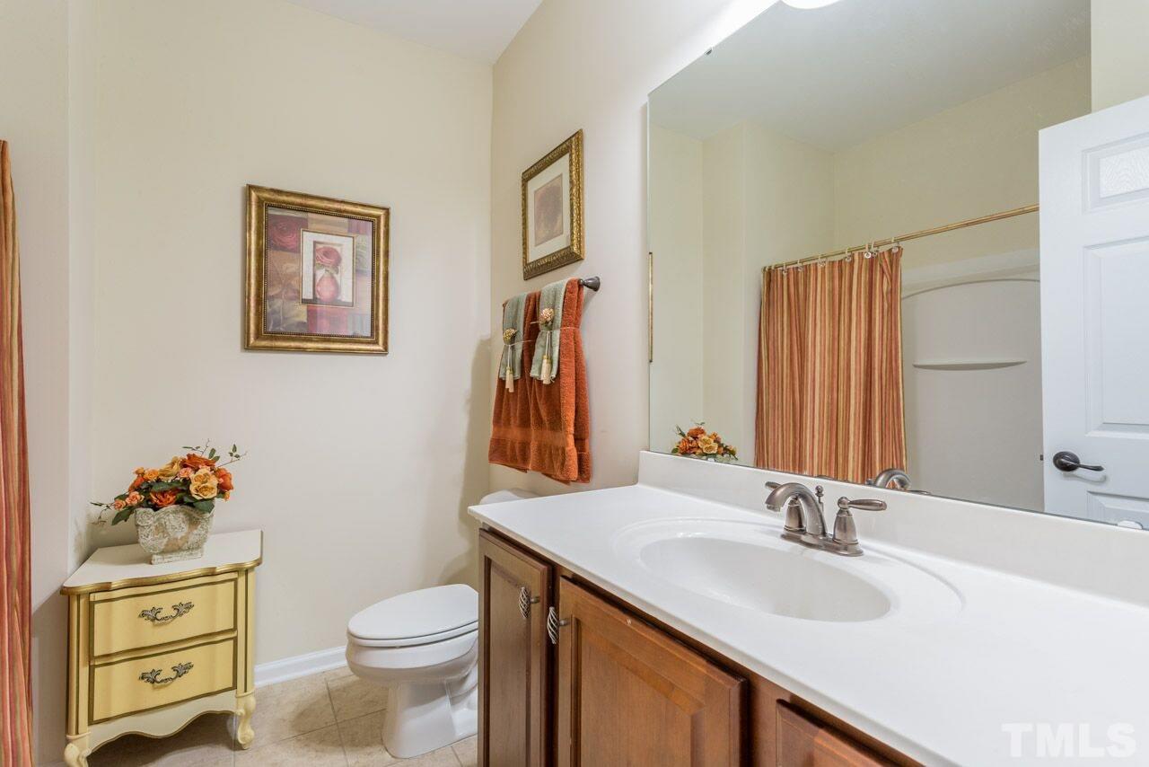 1217 Chapanoke Road Raleigh, NC 27603 - Photo 24 of 25 a bathroom with a toilet a sink and a mirror