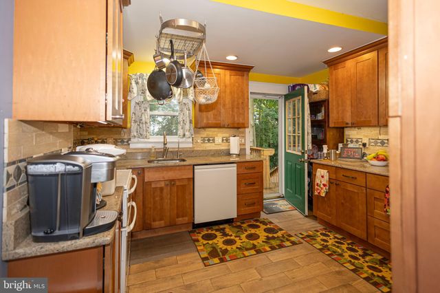 a kitchen with a sink appliances cabinets and furniture