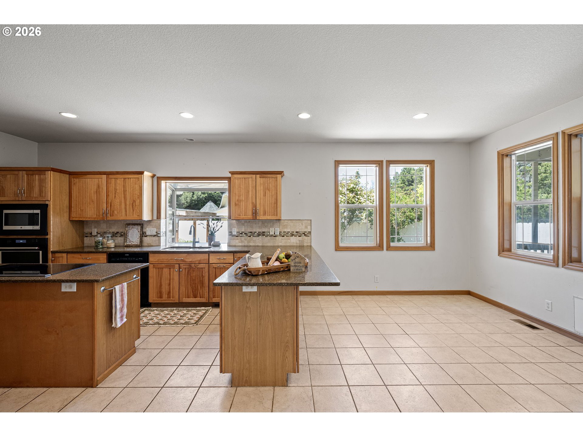 2218 Willow Loop Florence, OR 97439 - Photo 24 of 47 a open kitchen with granite countertop a stove top oven a sink a counter space and cabinets