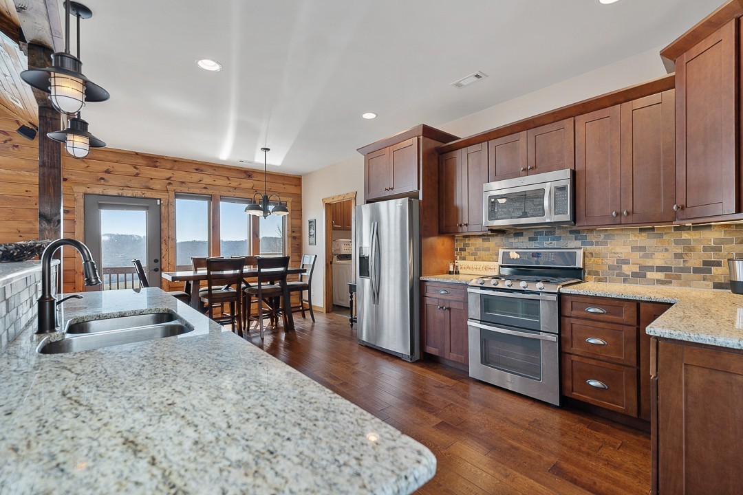 5320 Coconut Ridge Road Smithville, TN 37166 - Photo 17 of 47 a kitchen with stainless steel appliances granite countertop a refrigerator stove top oven and sink