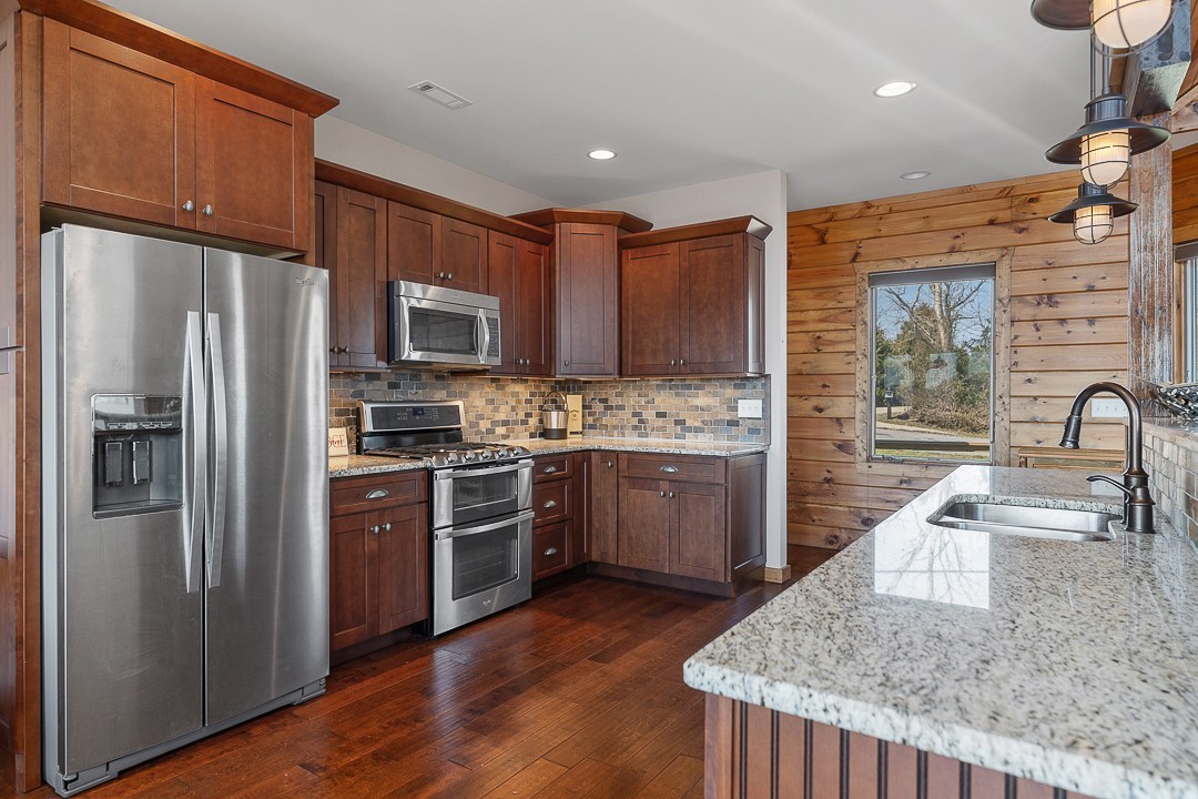 5320 Coconut Ridge Road Smithville, TN 37166 - Photo 18 of 47 a kitchen with stainless steel appliances granite countertop a refrigerator a stove and a sink with wooden floors
