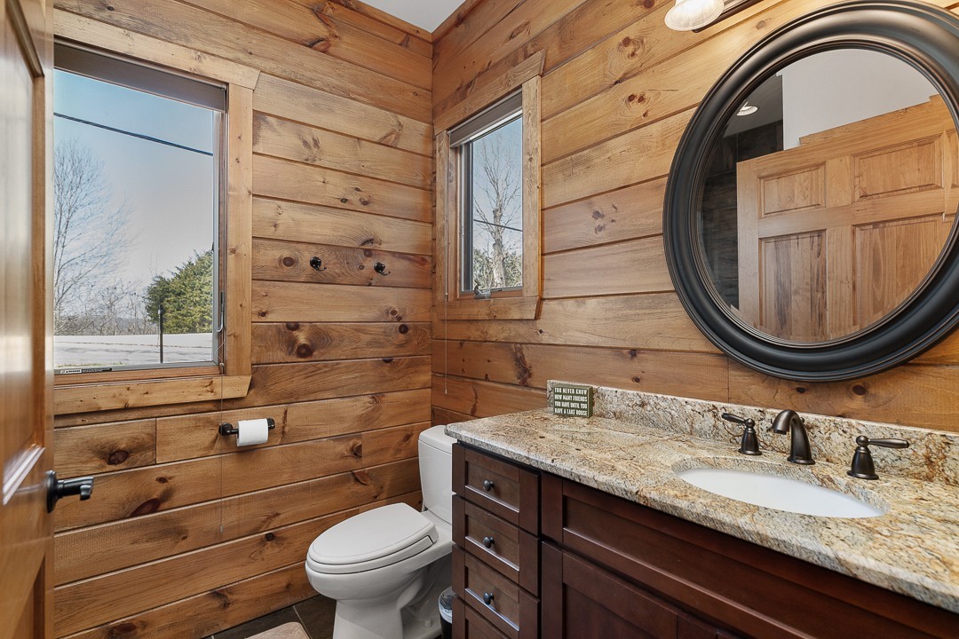 5320 Coconut Ridge Road Smithville, TN 37166 - Photo 41 of 47 a bathroom with a granite countertop toilet a sink and a mirror
