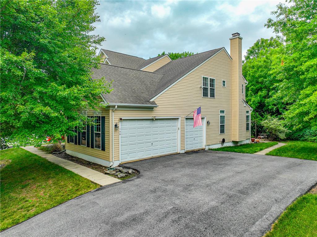 138 Clover Hollow Road Easton, PA 18045 - Photo 5 of 95 A classic exterior with a spacious driveway leading to the integrated garages, enveloped by mature trees.