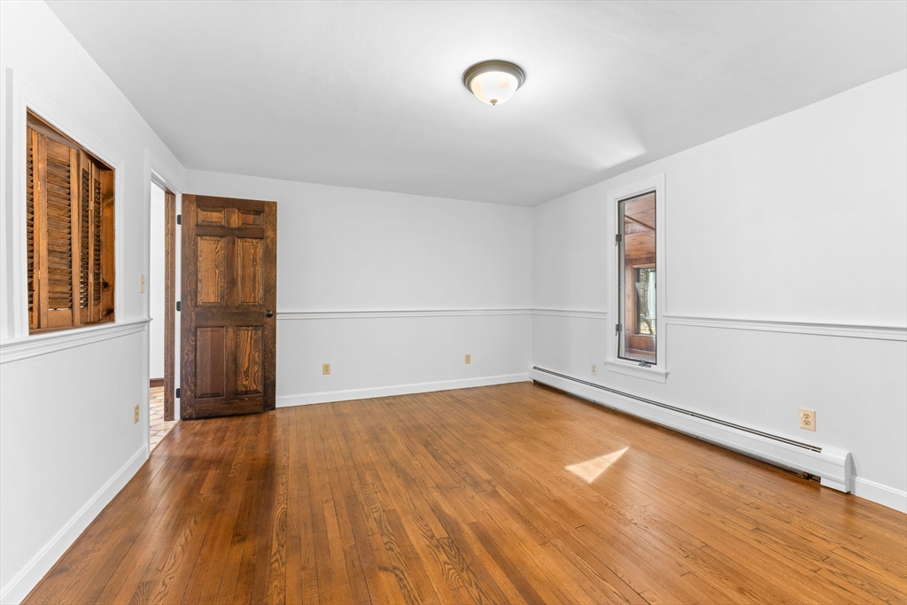 210 King Phillips Pathe Marshfield, MA 02050 - Photo 16 of 42 an empty room with wooden floor and windows