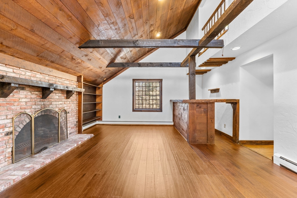 210 King Phillips Pathe Marshfield, MA 02050 - Photo 6 of 42 a view of a hallway with wooden floors and fireplace