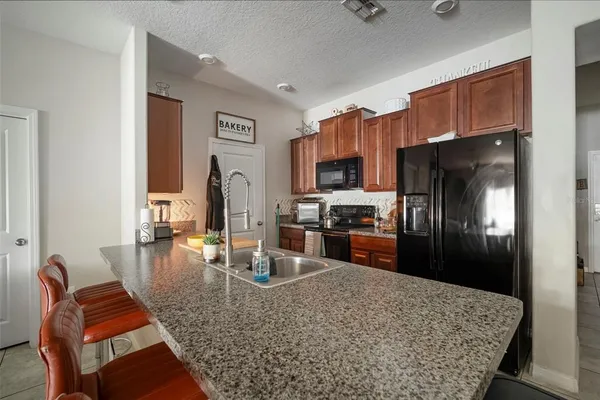 a kitchen with stainless steel appliances granite countertop a refrigerator oven stove a sink dishwasher and cabinets
