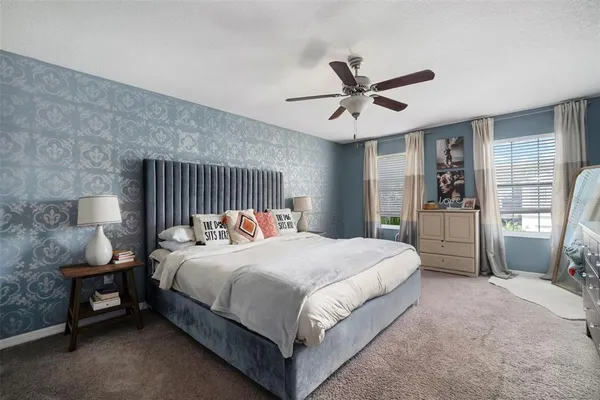 a bedroom with a bed and a ceiling fan