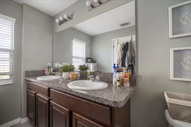 a bathroom with a granite countertop sink and a mirror