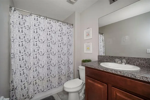 a bathroom with a granite countertop sink toilet and a mirror