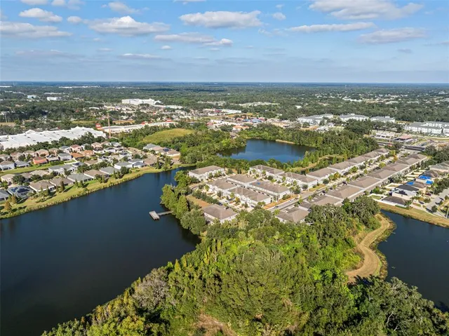 an aerial view of a city with lots of residential buildings ocean and mountain view in back