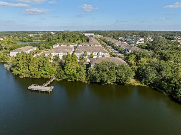 an aerial view of residential houses with outdoor space and lake view