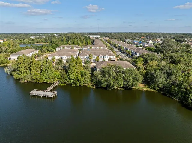 an aerial view of residential houses with outdoor space and lake view