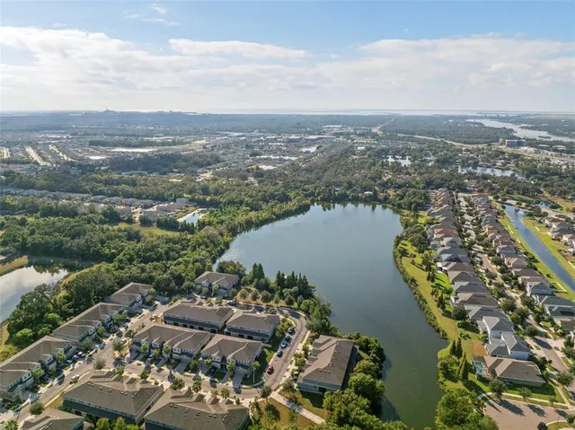 an aerial view of ocean and residential houses with outdoor space
