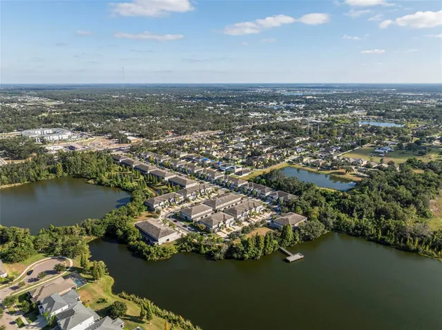an aerial view of ocean and residential houses with outdoor space