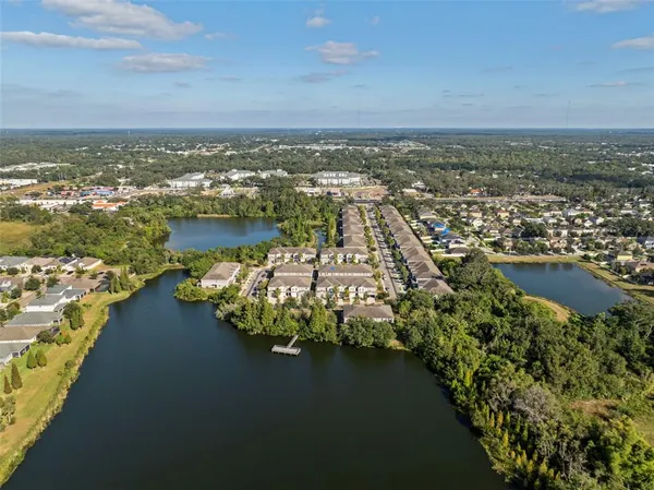 an aerial view of ocean and residential houses with outdoor space