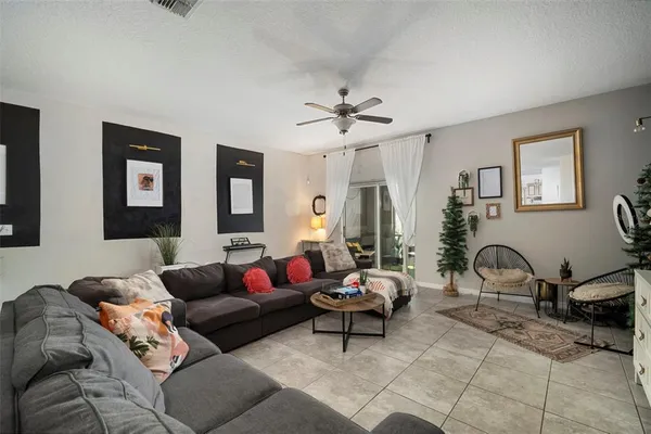 a living room with furniture a large window and a potted plant