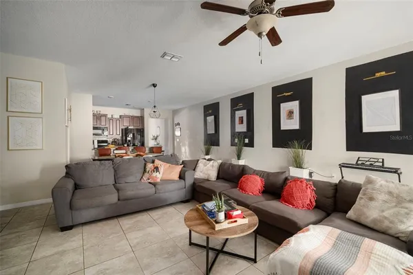 a living room with furniture and a ceiling fan